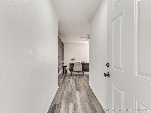 corridor with baseboards and dark wood-style flooring