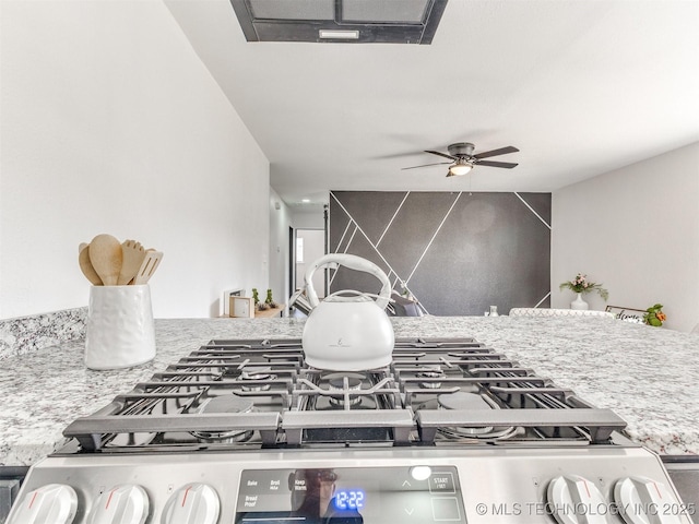 room details featuring visible vents, stainless steel gas range, and ceiling fan