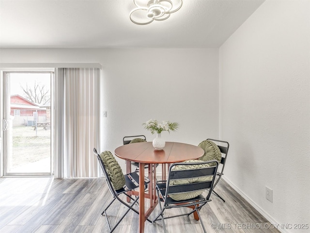 dining space featuring wood finished floors and baseboards