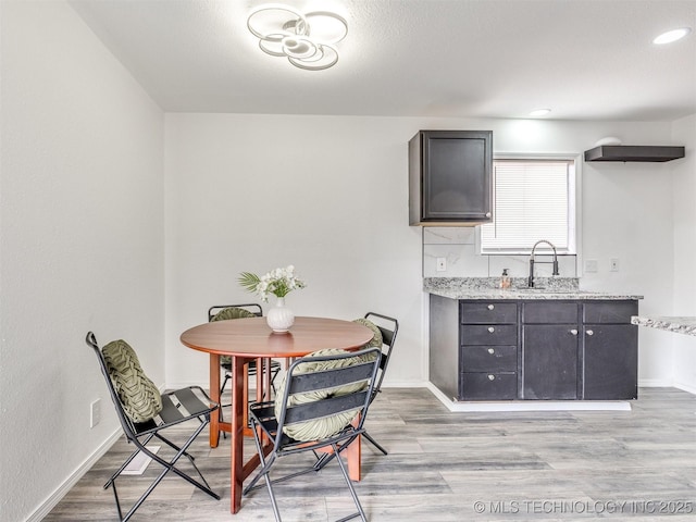 dining room with light wood-style flooring, recessed lighting, and baseboards