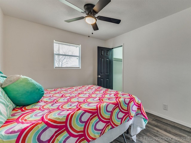 bedroom featuring baseboards, a textured ceiling, wood finished floors, and a ceiling fan