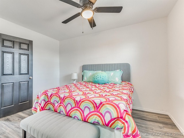 bedroom with ceiling fan, baseboards, and wood finished floors