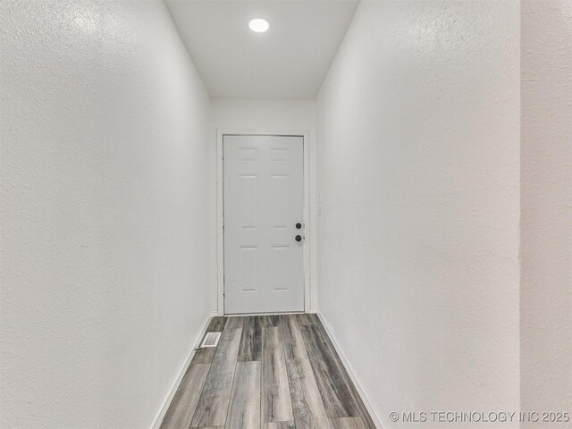 hallway featuring dark wood finished floors and baseboards