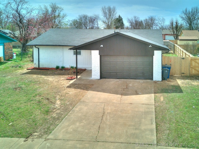 view of front facade featuring brick siding, driveway, an outdoor structure, and fence