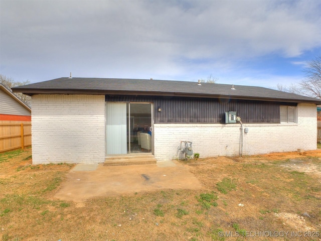 back of house with brick siding, a patio area, entry steps, and fence