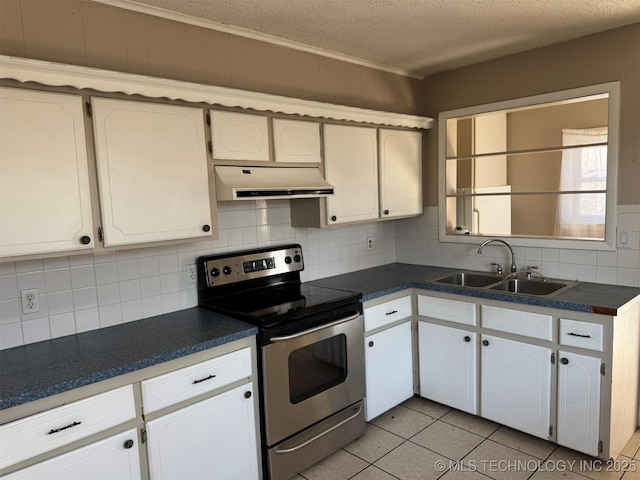 kitchen featuring electric range, backsplash, dark countertops, under cabinet range hood, and a sink