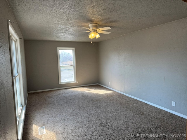 empty room with carpet, a textured ceiling, baseboards, and ceiling fan