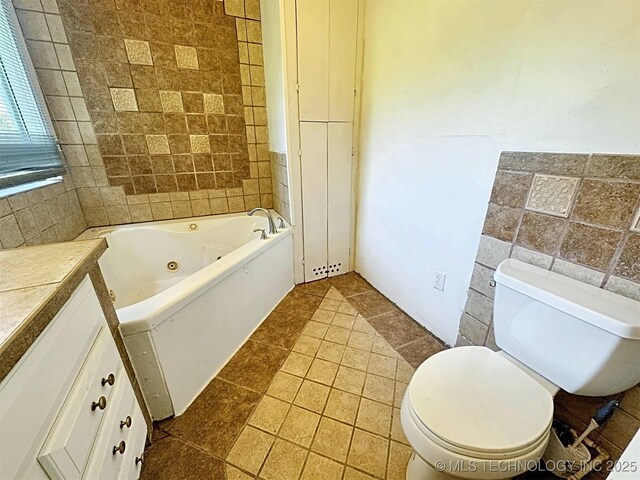 111 N Logan Dr, Tahlequah, OK 74464 - bathroom with a whirlpool tub, tile walls, vanity, and tile patterned floors