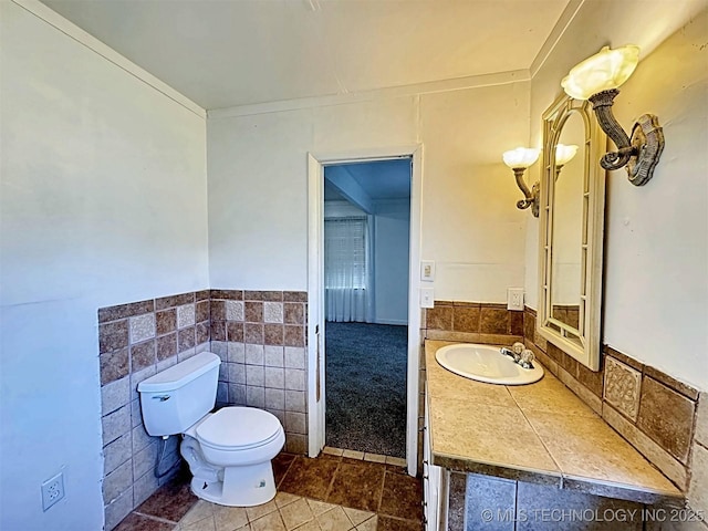 111 N Logan Dr, Tahlequah, OK 74464 - half bath featuring toilet, vanity, tile patterned flooring, and a wainscoted wall