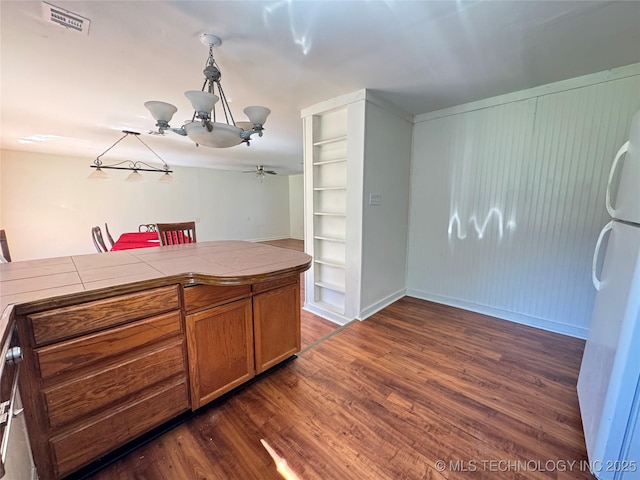 111 N Logan Dr, Tahlequah, OK 74464 - kitchen with tile countertops, brown cabinetry, dark wood-style floors, ceiling fan, and baseboards