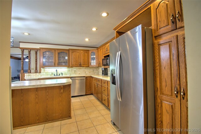 6508 W Cameron St, Sand Springs, OK 74127 - kitchen featuring backsplash, light countertops, light tile patterned floors, brown cabinets, and stainless steel appliances