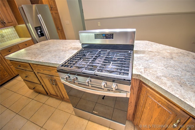 6508 W Cameron St, Sand Springs, OK 74127 - kitchen with brown cabinetry, light tile patterned floors, appliances with stainless steel finishes, and tasteful backsplash