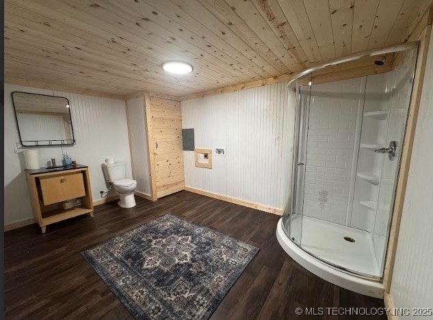 bathroom featuring toilet, wood finished floors, a shower stall, wood ceiling, and vanity