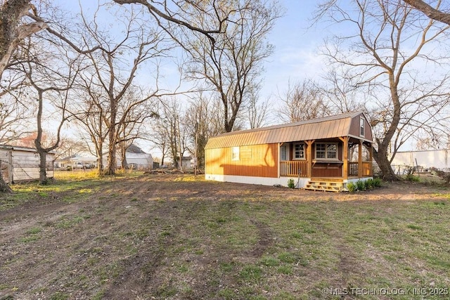 view of front of house with a gambrel roof, a porch, and a front lawn