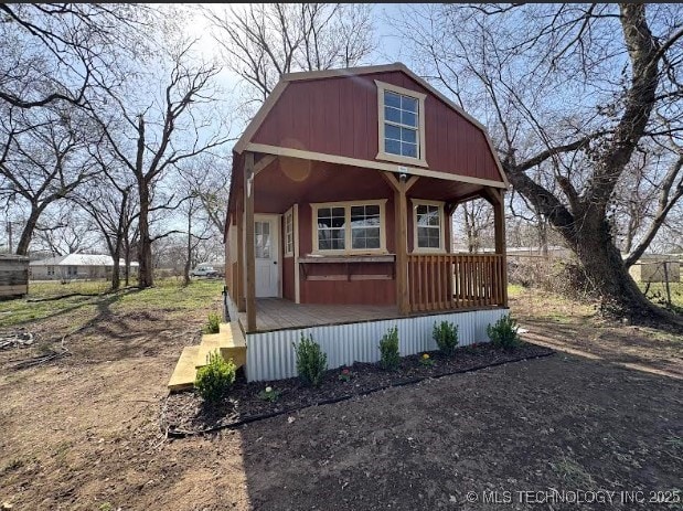 view of front of property featuring a gambrel roof and a porch