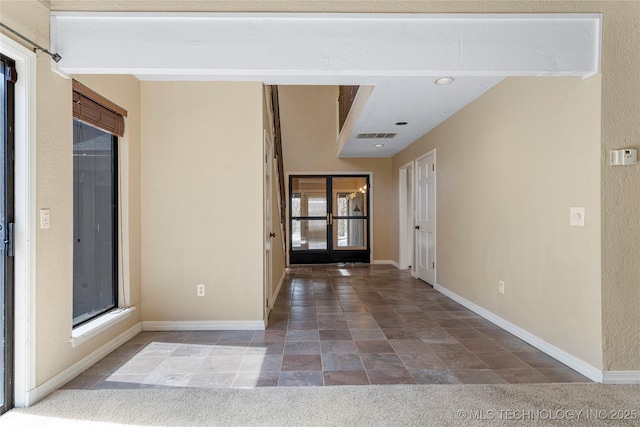 6505 S Oswego Ave, Tulsa, OK 74136 - carpeted entrance foyer with stone finish floor, baseboards, and visible vents
