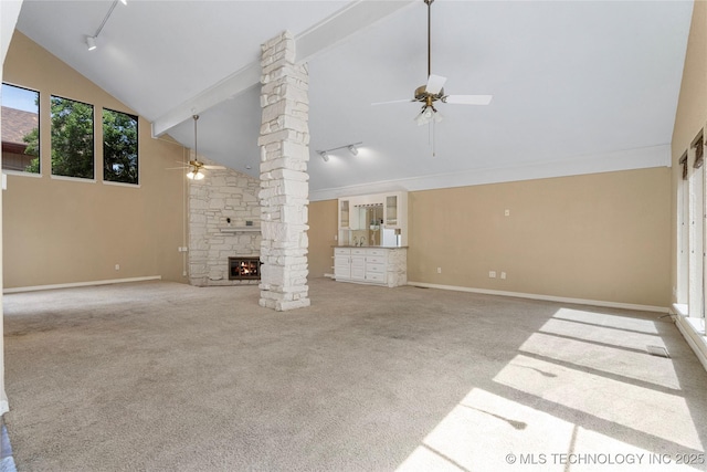 6505 S Oswego Ave, Tulsa, OK 74136 - unfurnished living room featuring ornate columns, carpet flooring, high vaulted ceiling, ceiling fan, and track lighting