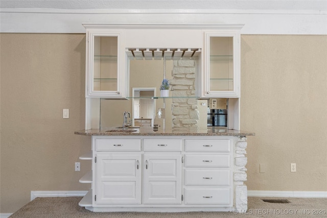 6505 S Oswego Ave, Tulsa, OK 74136 - kitchen with stone countertops, glass insert cabinets, white cabinets, and a sink