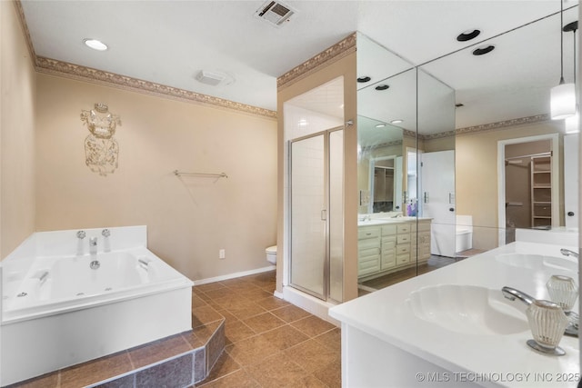 6505 S Oswego Ave, Tulsa, OK 74136 - full bath with visible vents, a shower stall, a tub with jets, vanity, and a walk in closet