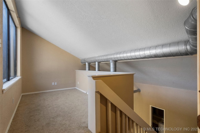 6505 S Oswego Ave, Tulsa, OK 74136 - corridor with an upstairs landing, lofted ceiling, carpet flooring, baseboards, and a textured ceiling