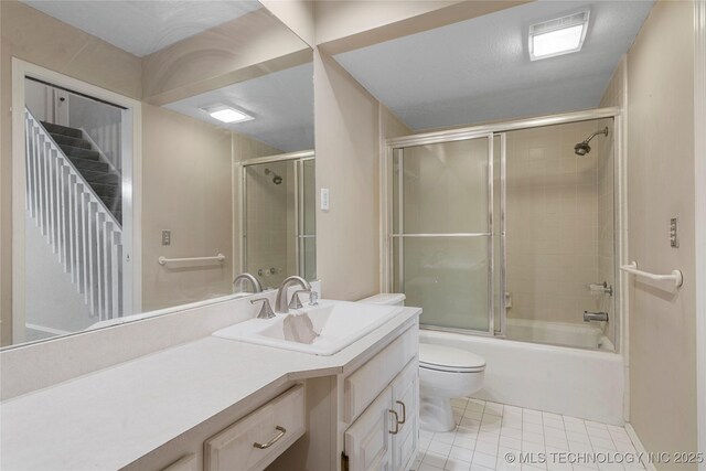 6505 S Oswego Ave, Tulsa, OK 74136 - bathroom featuring toilet, vanity, tile patterned flooring, and bath / shower combo with glass door