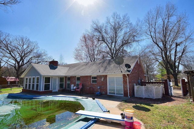 1430 Williams St, Fort Gibson, OK 74434 - rear view of house featuring a patio, fence, a covered pool, a chimney, and brick siding
