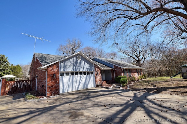 1430 Williams St, Fort Gibson, OK 74434 - view of side of home with a garage, brick siding, and driveway
