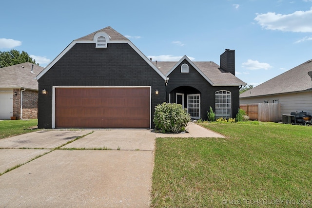 view of front of home with fence, a front yard, a chimney, a garage, and driveway