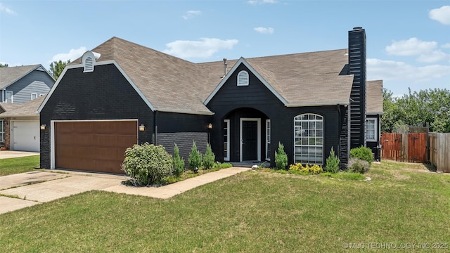 view of front of property featuring fence, an attached garage, a front yard, brick siding, and a chimney
