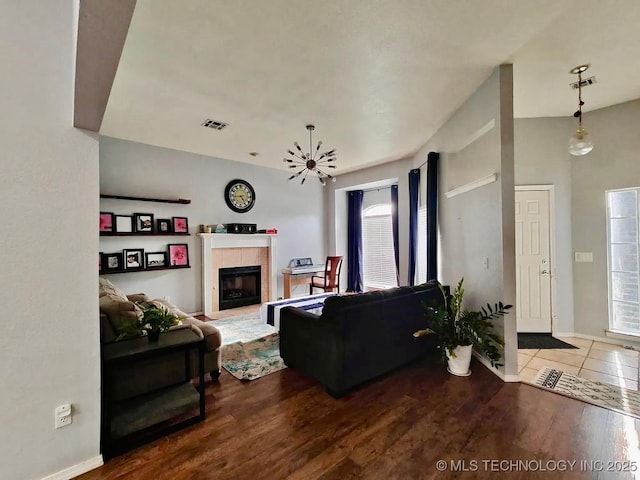 living room featuring visible vents, a fireplace, and wood finished floors