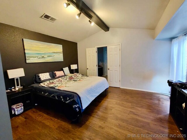 bedroom featuring wood finished floors, baseboards, visible vents, lofted ceiling with beams, and track lighting