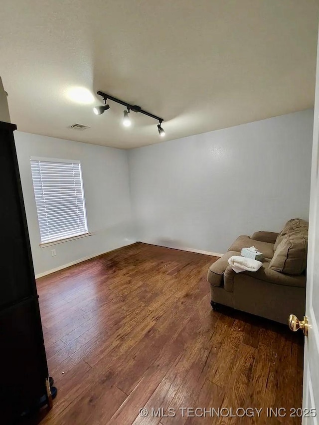unfurnished room with visible vents, baseboards, and wood finished floors