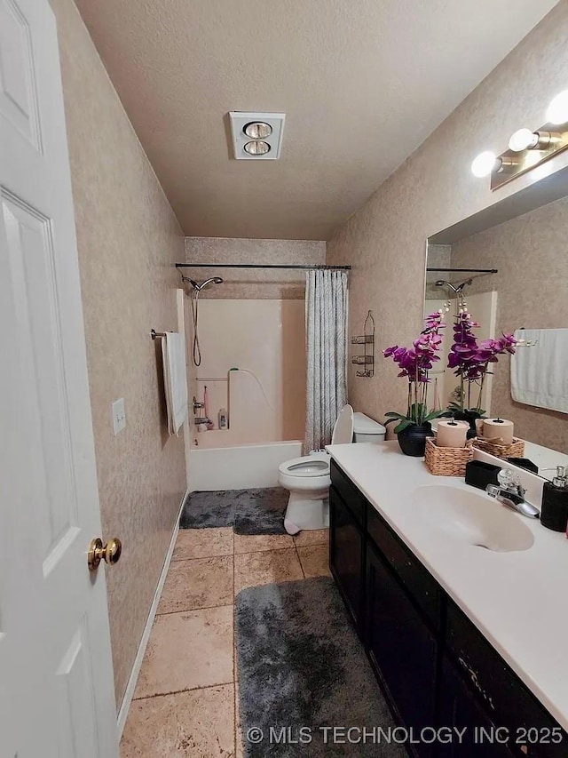 bathroom with toilet, shower / tub combo with curtain, baseboards, vanity, and a textured wall