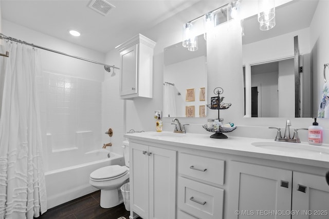 bathroom with wood finished floors, visible vents, toilet, and a sink