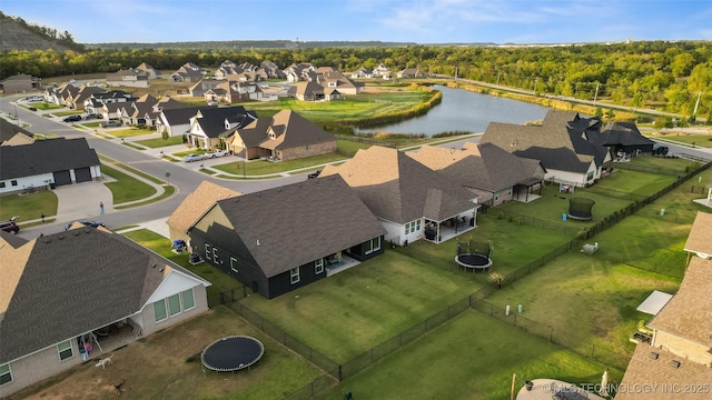 aerial view with a wooded view, a residential view, and a water view