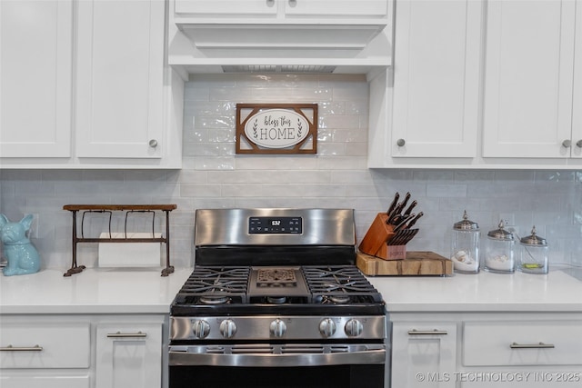 kitchen featuring stainless steel range with gas cooktop, white cabinetry, decorative backsplash, and light countertops