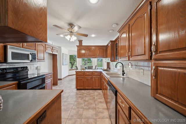 11712 E 121st St, Collinsville, OK 74021 - kitchen with appliances with stainless steel finishes, a sink, tasteful backsplash, brown cabinetry, and ceiling fan