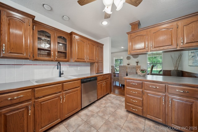 11712 E 121st St, Collinsville, OK 74021 - kitchen with stainless steel dishwasher, a sink, brown cabinets, light tile patterned floors, and recessed lighting