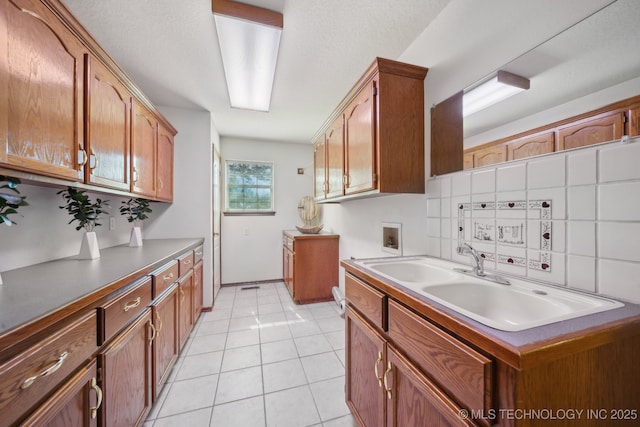 11712 E 121st St, Collinsville, OK 74021 - kitchen with a sink, decorative backsplash, and brown cabinetry