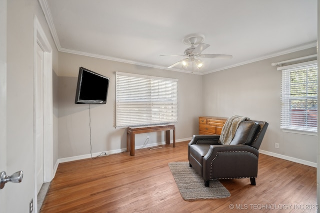 sitting room featuring wood finished floors, a ceiling fan, baseboards, and ornamental molding