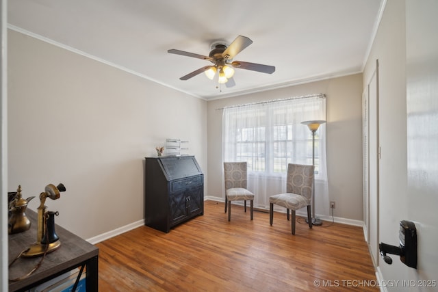 living area with baseboards, a ceiling fan, light wood-type flooring, and ornamental molding