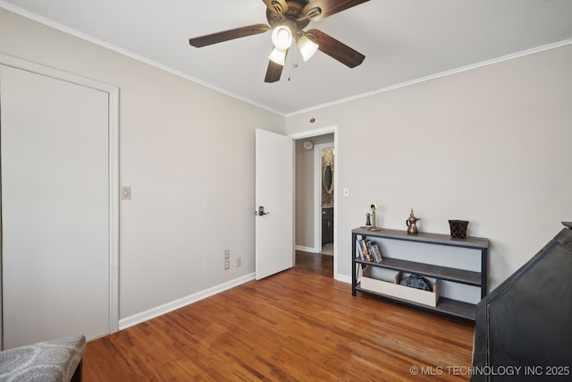 bedroom featuring ceiling fan, baseboards, wood finished floors, and crown molding