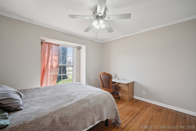 bedroom with ornamental molding, baseboards, and wood finished floors