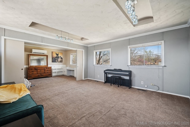 bedroom with visible vents, carpet, an AC wall unit, a tray ceiling, and ornamental molding