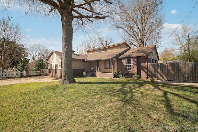 back of property with a yard and fence