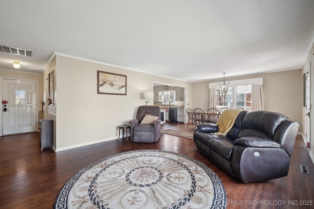 living room with visible vents, baseboards, wood finished floors, and crown molding