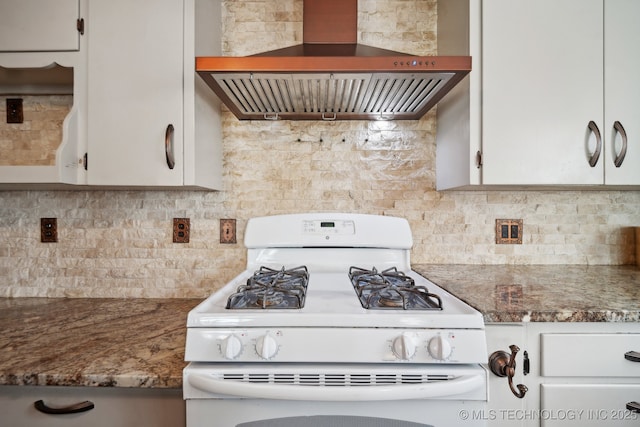 kitchen with backsplash, wall chimney exhaust hood, white cabinets, and white gas stove