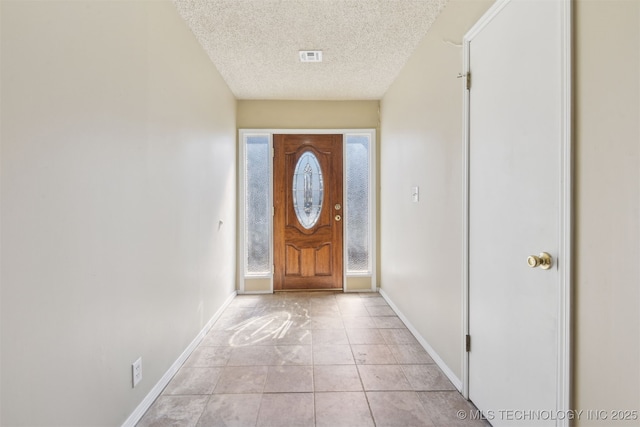 entryway featuring light tile patterned floors, visible vents, baseboards, and a textured ceiling