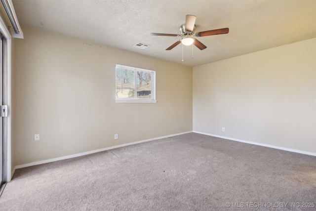 spare room featuring baseboards, visible vents, carpet floors, ceiling fan, and a textured ceiling