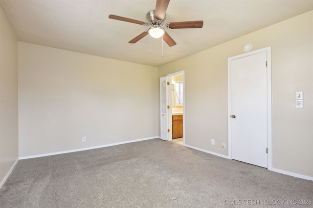 unfurnished bedroom with ensuite bath, carpet flooring, baseboards, and ceiling fan
